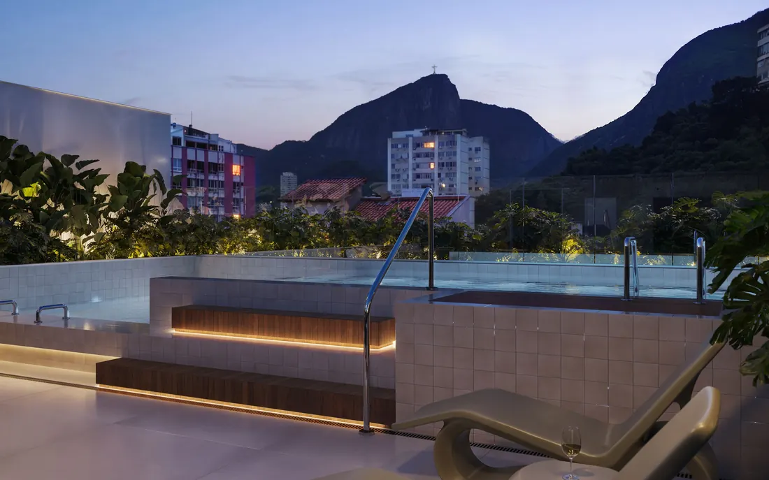 Piscina aquecida do rooftop do Be in Rio Nascimento Silva 45 ao anoitecer, com vista para as montanhas